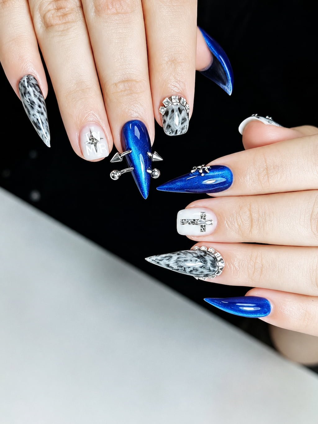Electric Blue Cat Claw Nails with Chrome Studs and Cross Details