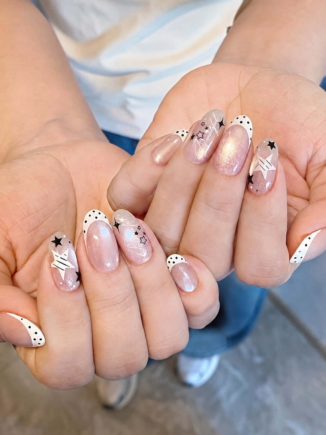 Shimmery Pink French Nails with Black Star and Polka Dot Details